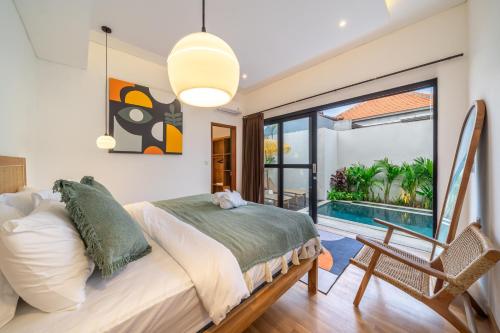 a bedroom with a bed and a view of a pool at Chic Brand New 2BDR Villa with Luxe Pool - The Ultimate Canggu Escape! in Kerobokan