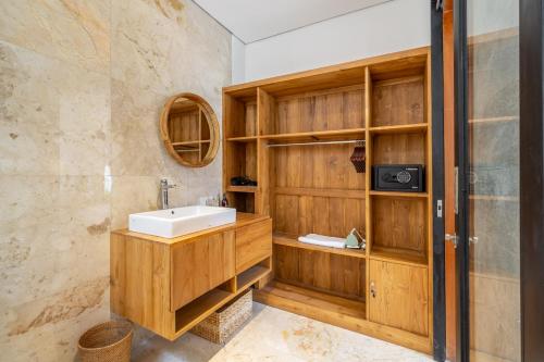 a bathroom with wooden cabinets and a sink at Chic Brand New 2BDR Villa with Luxe Pool - The Ultimate Canggu Escape! in Kerobokan
