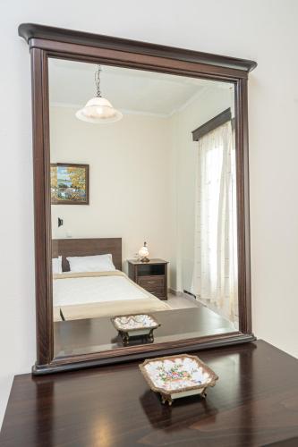 a large mirror in a bedroom with a bed at Lemonia Apartments Kefalonia in Andipáta Erísou