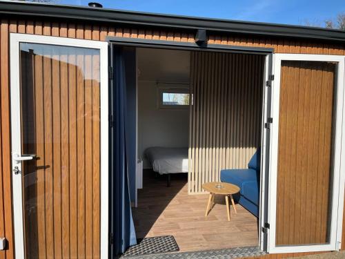 une porte ouverte menant à une chambre avec un lit dans l'établissement Studios au camping, à Saint-Martin-Plage