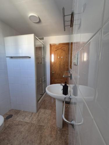 a white bathroom with a sink and a shower at 2ºA Escobar in Nerja