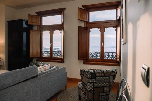 a living room with a couch and windows at Céntrico con vistas a la ría by CABANA Rentals in Vigo