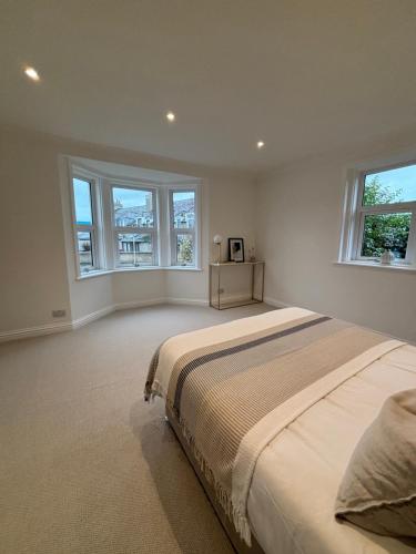 une chambre avec un grand lit et deux fenêtres dans l'établissement Halfred House, à Wick