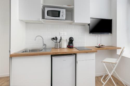 une cuisine avec un comptoir avec un évier et un micro-ondes dans l'établissement Paimpont, à Brest