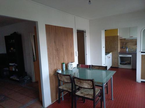 une cuisine avec une table et des chaises dans une pièce dans l'établissement Chambre chez l habitant proche Paris, à Massy