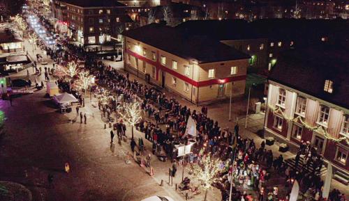 a crowd of people walking down a street with christmas lights at Alingsås Vandrarhem in Alingsås