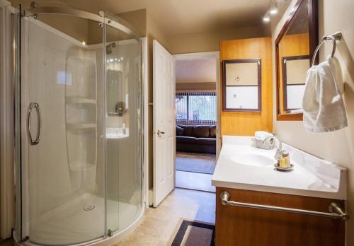 ein Badezimmer mit Dusche und Waschbecken in der Unterkunft Cole's Bay Vacation Retreat Petie's Cottage in YYJ