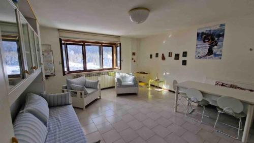 a living room with a couch and a table and chairs at Bilocale in residence San Nicola 3 in San Massimo