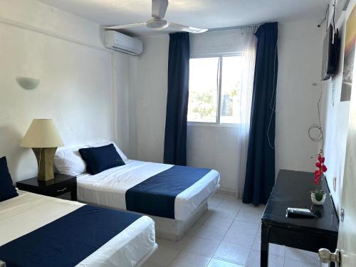 a hotel room with two beds and a window at Hotel Independencia in Progreso