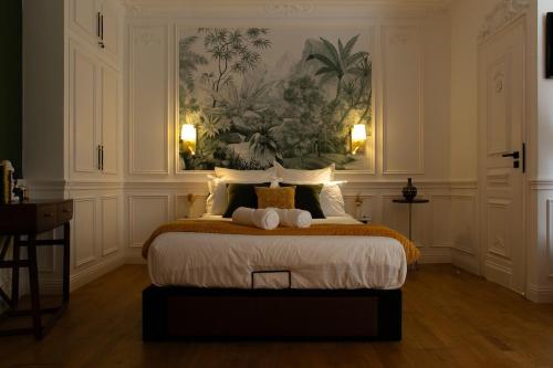 une chambre avec un grand lit avec un tableau au mur dans l'établissement Studio charmant Parking & terrasse près du centre, à Nantes