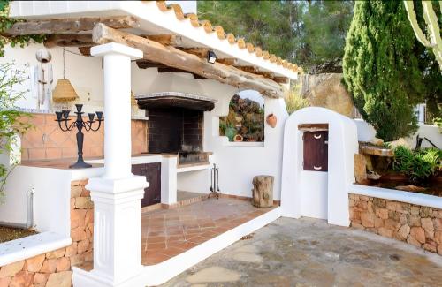a white house with an outdoor fireplace at Gothia Villa Exclusiva Villa con Piscina Sauna in Illes Balears