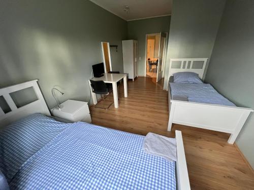 two beds in a room with a desk and a desk at Bett4-you Pinneberg - Prisdorf in Prisdorf