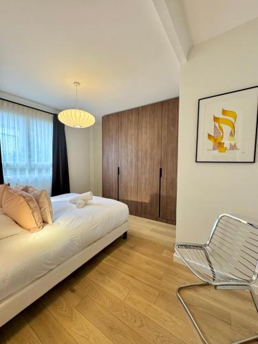 une chambre avec un lit et une chaise dedans dans l'établissement La Maison d Ernest, avec jardin, à deux pas de la gare, à Rennes