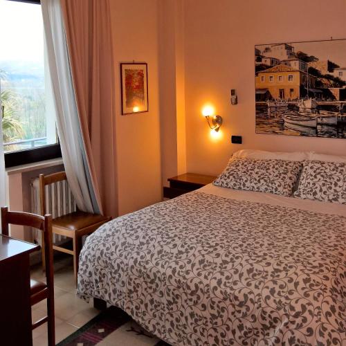 a bedroom with a bed and a large window at Hotel La Rotonda in Cepagatti