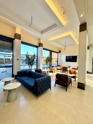 a large living room with a blue couch and chairs at Olive INN Berlin in Berlin