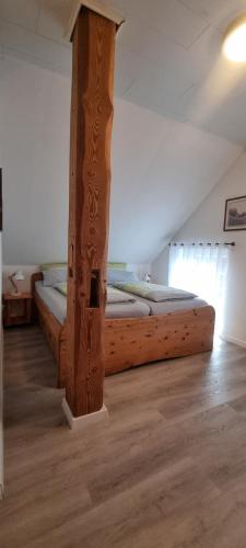 Bett in einem Zimmer mit Holzpfosten in der Unterkunft Gartenwohnung in Norden