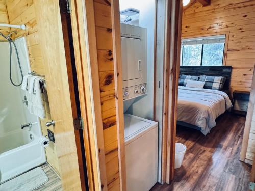 a bedroom in a tiny house with a bed and a tub at Pet Friendly Retreat in Rim Country! With a Spa! in Mogollon Airpark