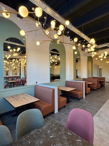 a dining room with tables and chairs and lights at Olive INN Berlin in Berlin