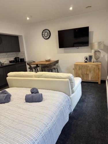 a living room with two beds and a tv on the wall at Town Centre Cosy Flat in Merthyr Tydfil