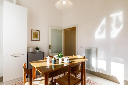 a kitchen and dining room with a wooden table and chairs at Casa Calise Elegant 1920s Villa with Garage in Siena