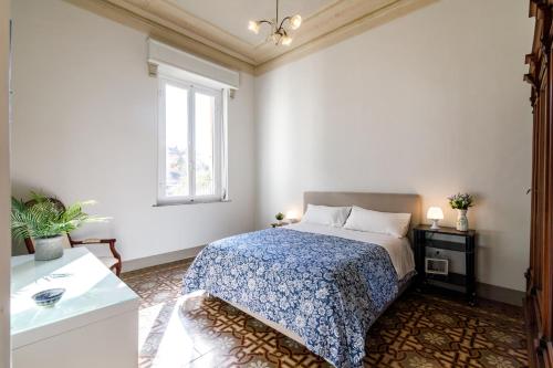 a white bedroom with a bed and a window at Casa Calise Elegant 1920s Villa with Garage in Siena