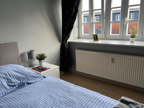 a bedroom with a bed and a window with a radiator at Bett4-you Pinneberg - Prisdorf in Prisdorf