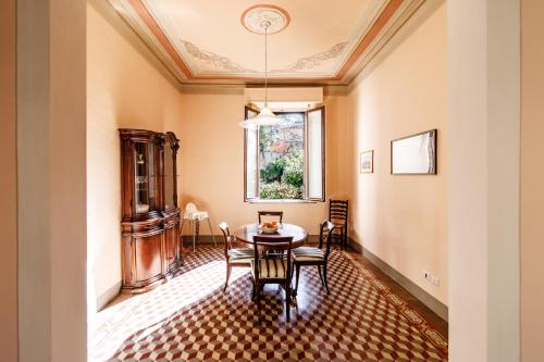 a dining room with a table and chairs and a window at Casa Calise Elegant 1920s Villa with Garage in Siena