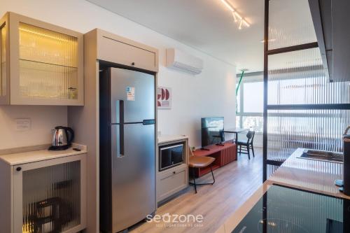 a kitchen with a refrigerator and a living room at Apartamentos a 850m da Praia Brava - RCX in Cabeçudas