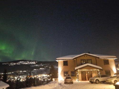 a house with the aurora in the sky at night at Trysil turistesenter hytte in Trysil