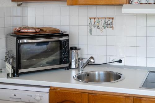 eine Küchentheke mit Spüle und Mikrowelle in der Unterkunft Apartment K & K in Baška Voda