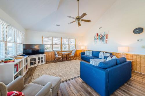 a living room with a blue couch and a tv at Sound Waves in Duck
