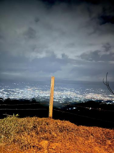 a wooden pole on top of a hill with a city at Finca Formentera, este tu pequeño paraíso in Dosquebradas