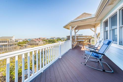 a blue rocking chair on a porch with a table at Sound Waves in Duck