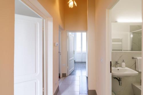 a white bathroom with a sink and a mirror at Casa Calise Elegant 1920s Villa with Garage in Siena