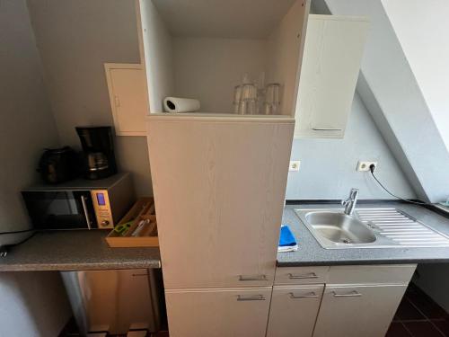 a small kitchen with a sink and a counter at Bett4-you Pinneberg - Prisdorf in Prisdorf