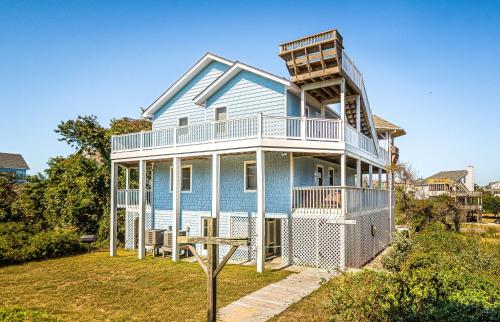 a blue house with a balcony on top of it at Sound Waves in Duck