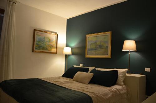 a bedroom with a bed with two pictures on the wall at Villa Noemi in Scarlino