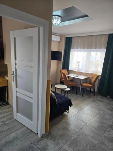 a door leading to a living room with a table at Eldom-NOCLEGI, Kolejowa 15 Wągrowiec in Wągrowiec