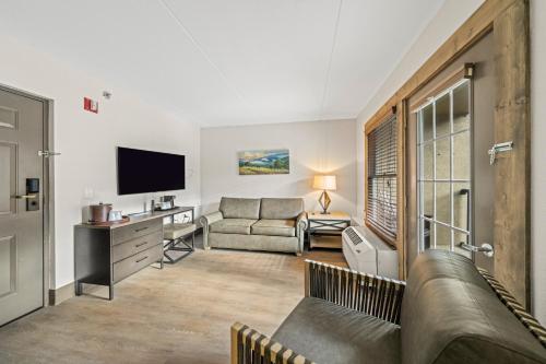 a living room with a couch and a television at Black Bear Inn & Suites in Gatlinburg
