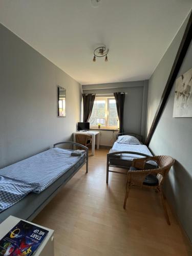 a room with two beds and a chair in it at Bett4-you Pinneberg - Prisdorf in Prisdorf