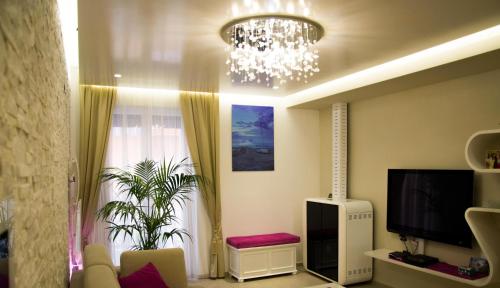 a living room with a chandelier and a tv at Bassa Marea in Grottammare