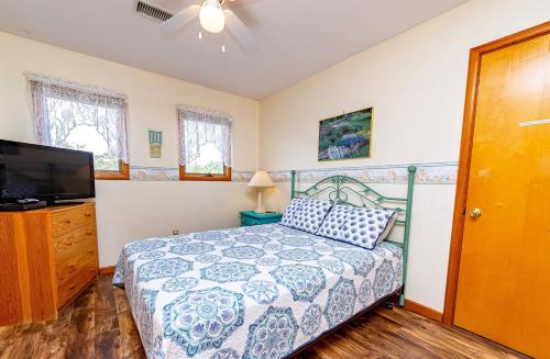 a bedroom with a bed and a flat screen tv at Misty Blue in Corolla
