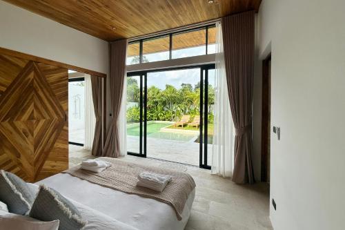 波普托Golden Palm Pool Villa near Fishermans Village的一间卧室，里面有一张床和一扇大窗户。