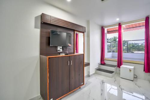 a living room with a flat screen tv on a cabinet at Antonios Calangute beach in Calangute