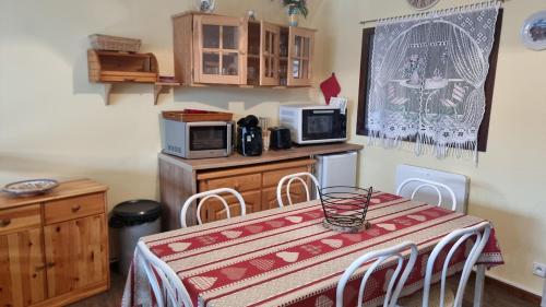 une cuisine avec une table avec des chaises et un micro-ondes dans l'établissement Chez Mady - Terrasse, Vue Montagne & Proche Ski, à Bussang