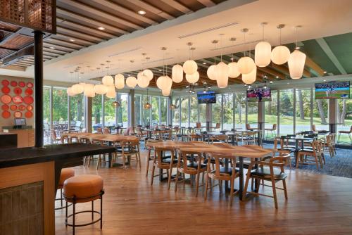 萨尼亚Four Points by Sheraton Point Edward Sarnia的有木桌椅和窗户的餐厅