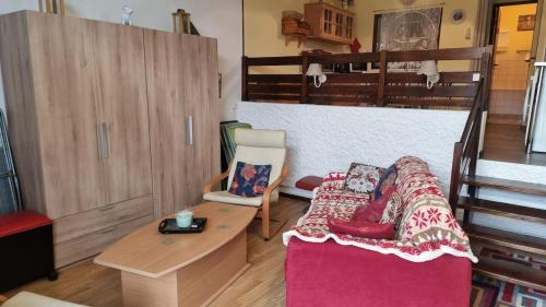 een woonkamer met een bed en een tafel bij Chez Mady - Terrasse, Vue Montagne & Proche Ski in Bussang