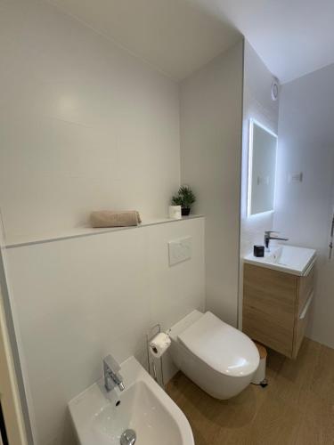 une salle de bain blanche avec des toilettes et un lavabo dans l'établissement Le studio Palm Beach, Clim ,Parking, Neuf, à Cannes