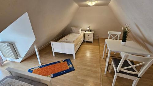 a attic room with a bed and a table and a desk at Holiday Homes Buchholz in Büsum