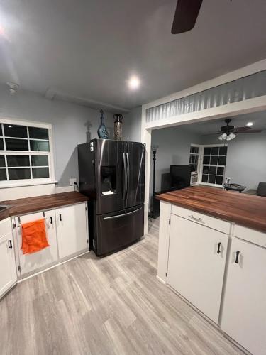 a kitchen with a stainless steel refrigerator and white cabinets at Old Oak Ranch in Cameron